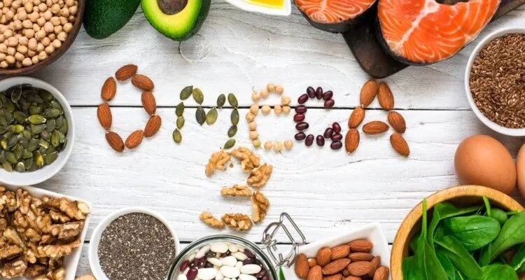 Rijec omega 3 ispisana s orasastim plodovima okruzena namirnicama bogatim omega-3 masnim kiselinama