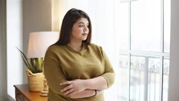 Pretila žena razmišlja o uzimanju kurkumina koji može pomoći sa smanjenjem kilograma