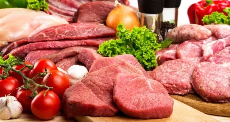 Crveno meso, rajcice, luk, cesnjak i zacini na stolu