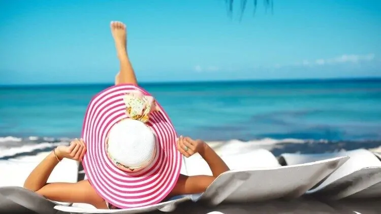 Mlada žena se sunča na plaži kako bi doskočila nedostatku vitamina D