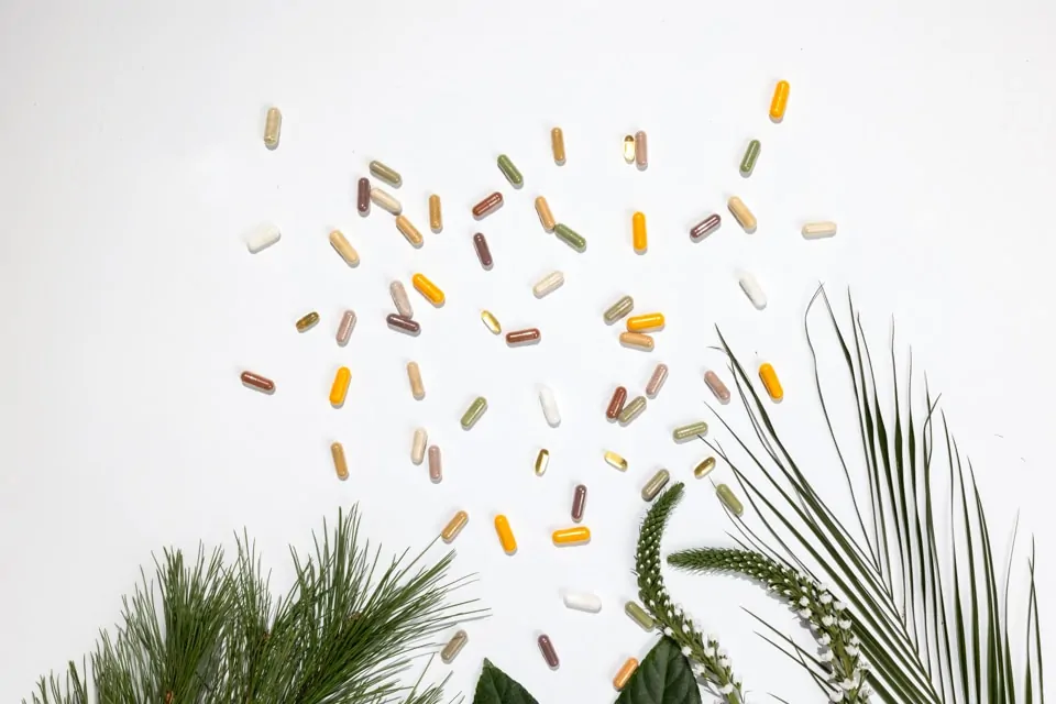 Kapsule Hug Your Life dodataka prehrani na bijelol pozadini s biljkama